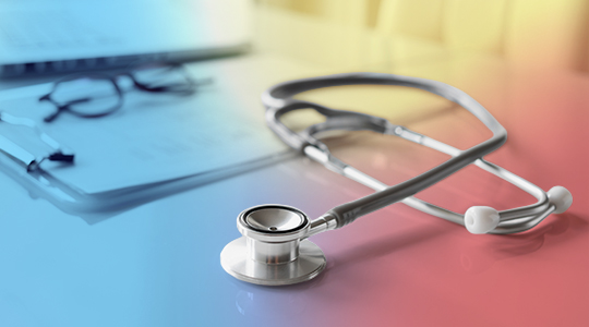A stethoscope resting on a desk next to a clipboard and glasses, representing healthcare and medical practice