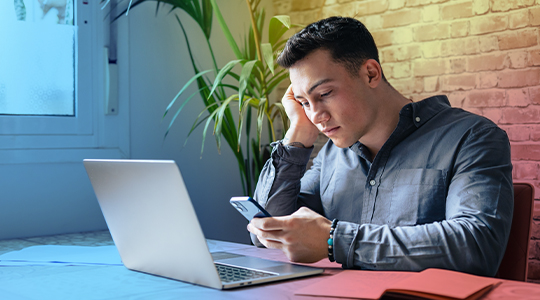 Unhappy young man looking at phone, feeling nervous about internet disconnection and lost data